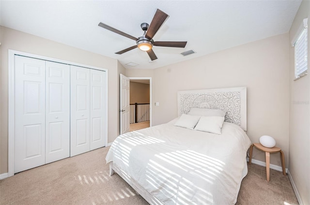 bedroom featuring ceiling fan, a closet, and light carpet