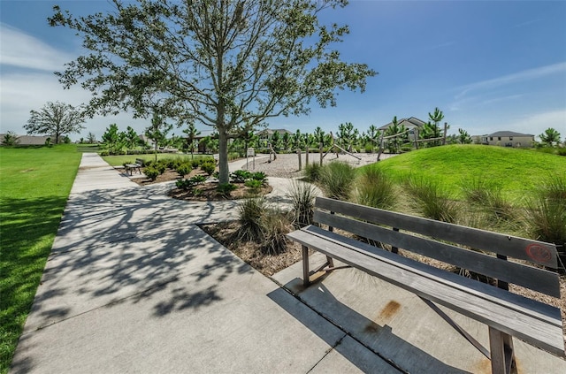 view of community with volleyball court and a lawn