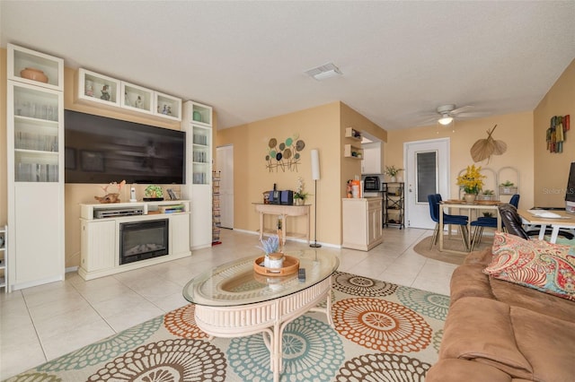 tiled living room featuring a textured ceiling and ceiling fan