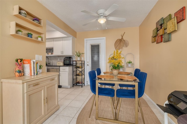 kitchen featuring backsplash, ceiling fan, light tile patterned floors, and a textured ceiling