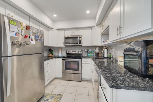 kitchen with tasteful backsplash, stainless steel appliances, sink, white cabinetry, and light tile patterned flooring