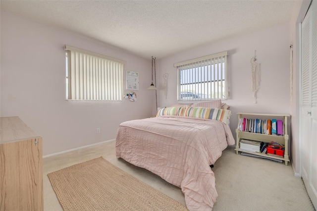 carpeted bedroom with a textured ceiling and a closet