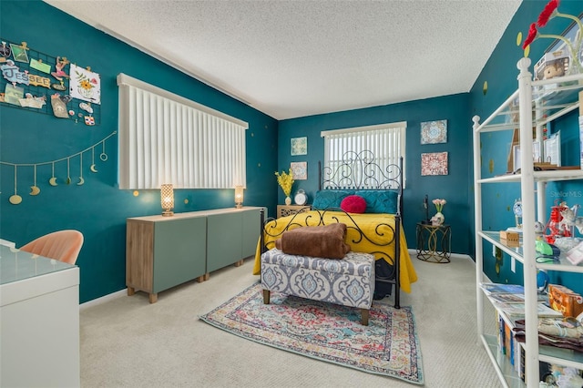 bedroom with light colored carpet and a textured ceiling