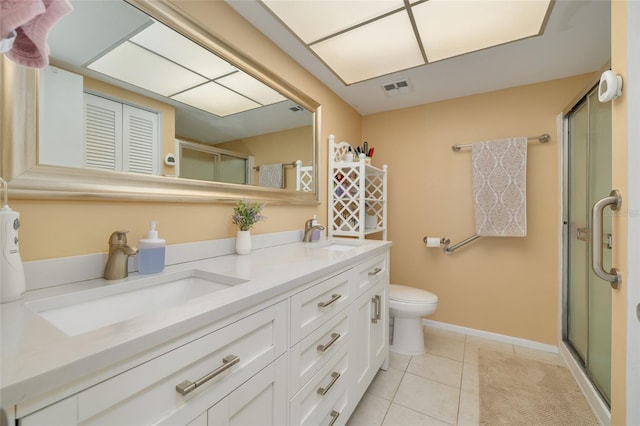 bathroom featuring tile patterned flooring, vanity, toilet, and walk in shower