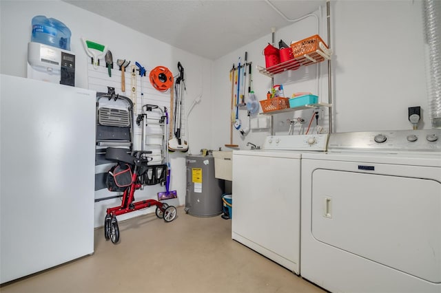 washroom featuring electric water heater, washer and clothes dryer, and sink