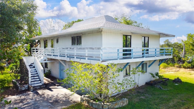 view of side of property featuring a lawn and a deck