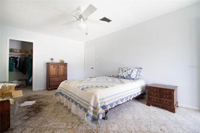 bedroom with a spacious closet, light colored carpet, a closet, and ceiling fan