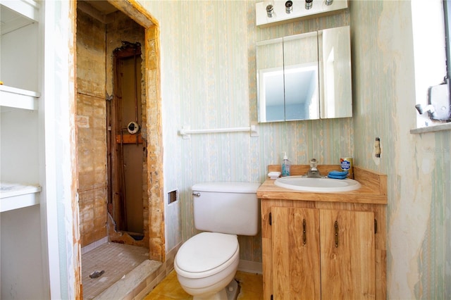 bathroom with vanity, toilet, and a tile shower