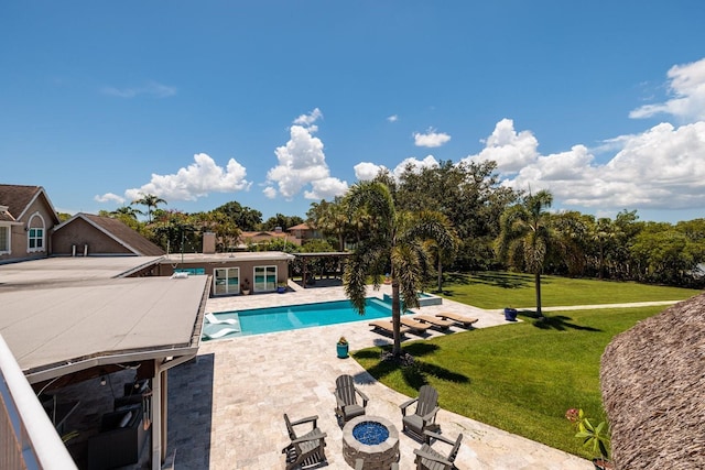 view of swimming pool featuring a patio, an outdoor fire pit, and a lawn