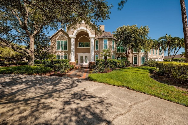 mediterranean / spanish house featuring a front yard and french doors