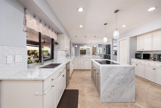 kitchen featuring kitchen peninsula, decorative backsplash, black appliances, decorative light fixtures, and a large island