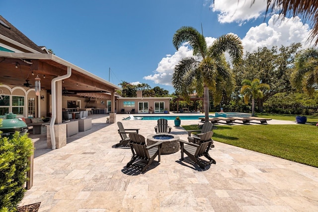 exterior space with ceiling fan, an outdoor kitchen, and an outdoor fire pit