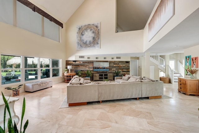 living room with a fireplace and a high ceiling