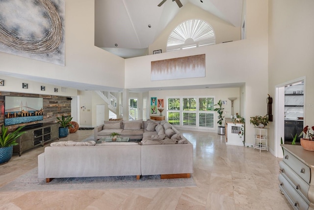 living room with ceiling fan and a high ceiling