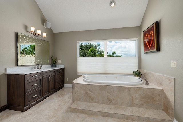 bathroom with vanity, a textured ceiling, tiled bath, and vaulted ceiling