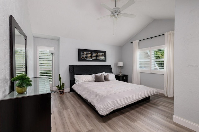 bedroom featuring ceiling fan, light wood-type flooring, and lofted ceiling