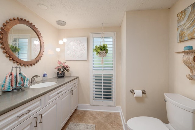 bathroom featuring a textured ceiling, vanity, and toilet