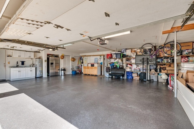 garage featuring stainless steel refrigerator with ice dispenser, a garage door opener, and water heater