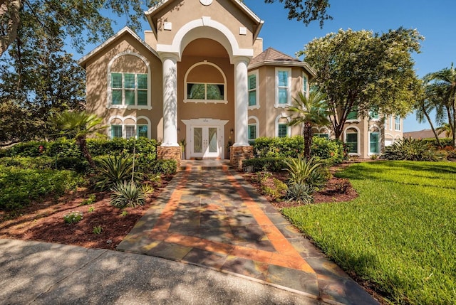 mediterranean / spanish-style home with french doors and a front yard