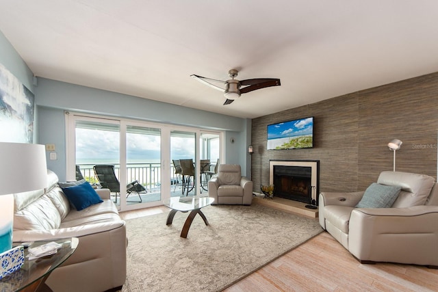 living room with ceiling fan and light hardwood / wood-style flooring