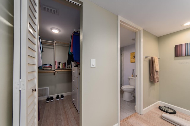 bathroom with hardwood / wood-style floors and toilet