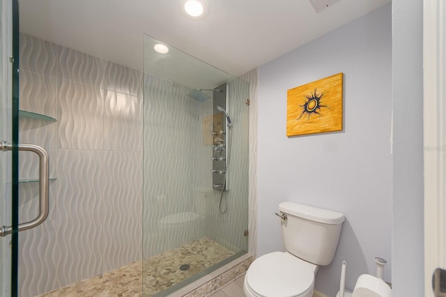 bathroom with tile patterned floors, a shower with shower door, and toilet