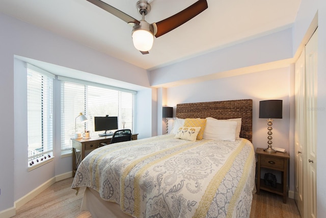 bedroom featuring multiple windows, a closet, light hardwood / wood-style flooring, and ceiling fan