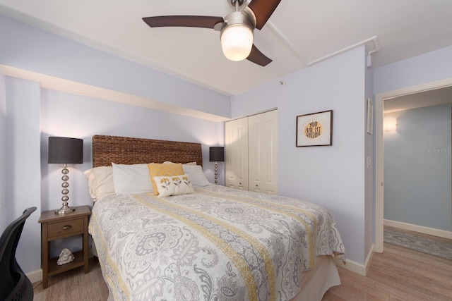 bedroom with ceiling fan, a closet, and light hardwood / wood-style floors