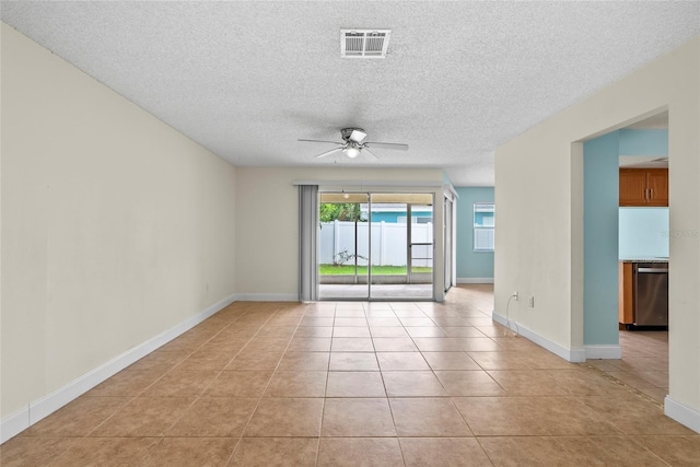 tiled empty room with ceiling fan and a textured ceiling