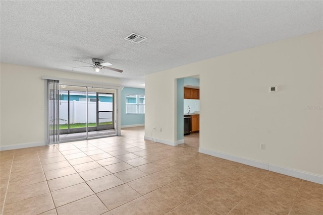 tiled empty room featuring sink, a textured ceiling, and ceiling fan