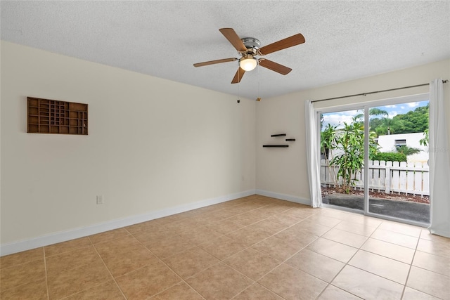 unfurnished room featuring ceiling fan, light tile patterned floors, and a textured ceiling