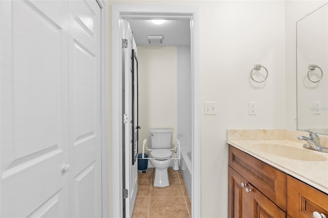 bathroom with tile patterned floors, vanity, toilet, and a textured ceiling