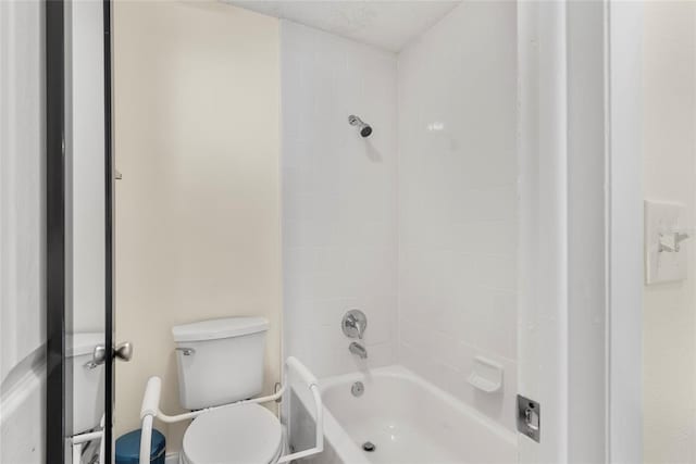 bathroom with tiled shower / bath combo and toilet