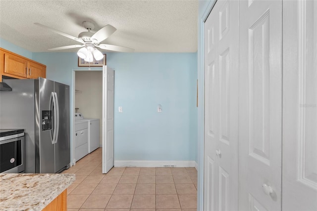 kitchen featuring separate washer and dryer, a textured ceiling, light tile patterned floors, appliances with stainless steel finishes, and ceiling fan