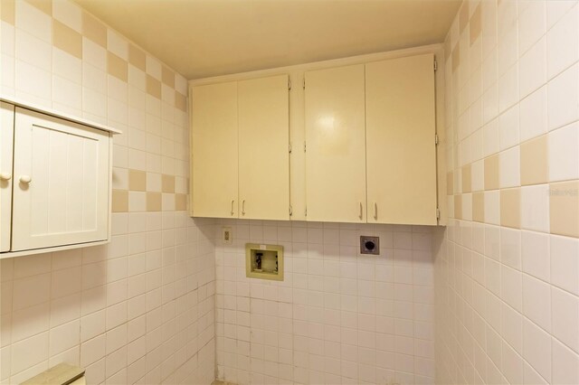 washroom featuring electric dryer hookup, tile walls, cabinets, and hookup for a washing machine