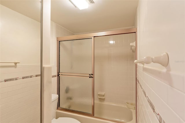 bathroom featuring shower / bath combination with glass door and toilet