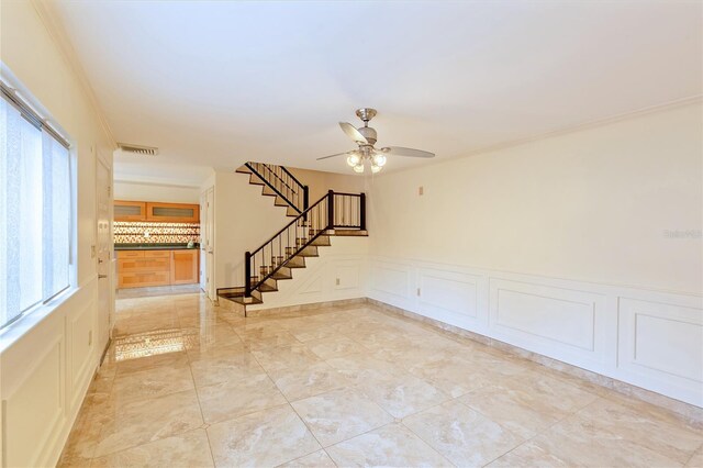 spare room featuring light tile patterned floors, ceiling fan, plenty of natural light, and crown molding