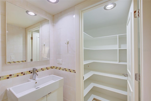 bathroom featuring vanity and tile walls