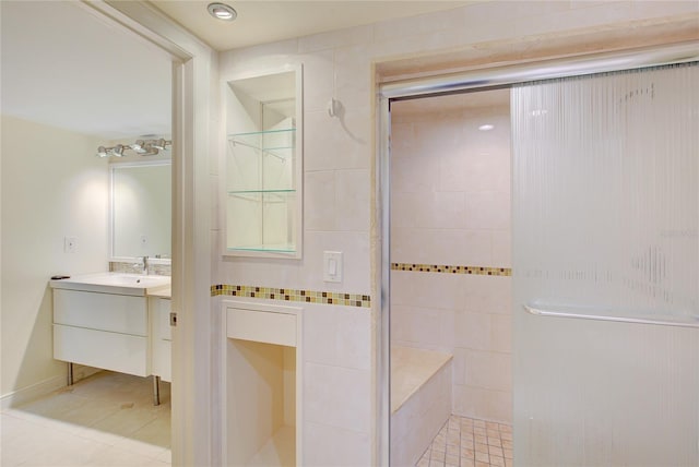 bathroom featuring vanity, tile walls, a tile shower, and tile patterned floors