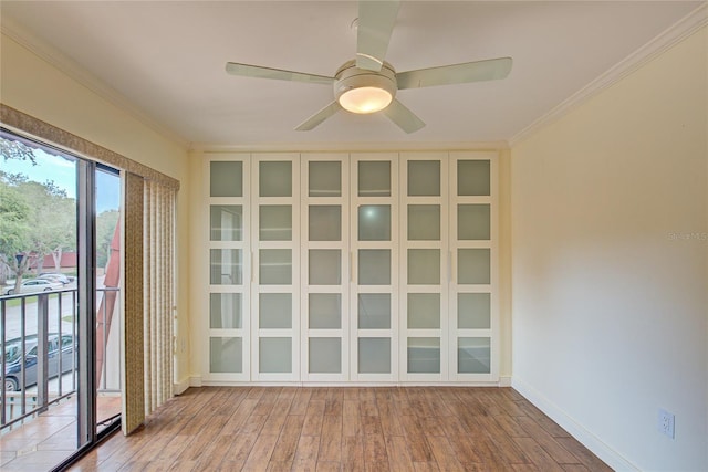 spare room featuring wood-type flooring, ceiling fan, and crown molding