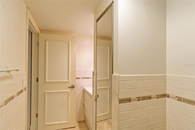 bathroom featuring tile walls, tile patterned floors, and vanity