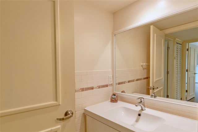 bathroom with vanity and tile walls