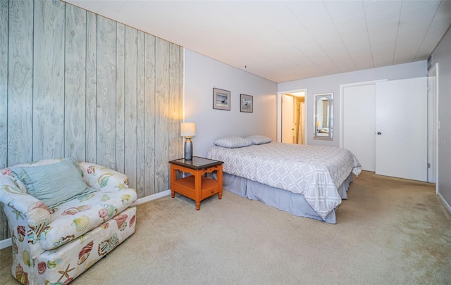 carpeted bedroom featuring wood walls