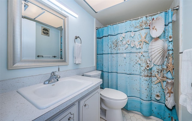 bathroom featuring vanity, curtained shower, and toilet