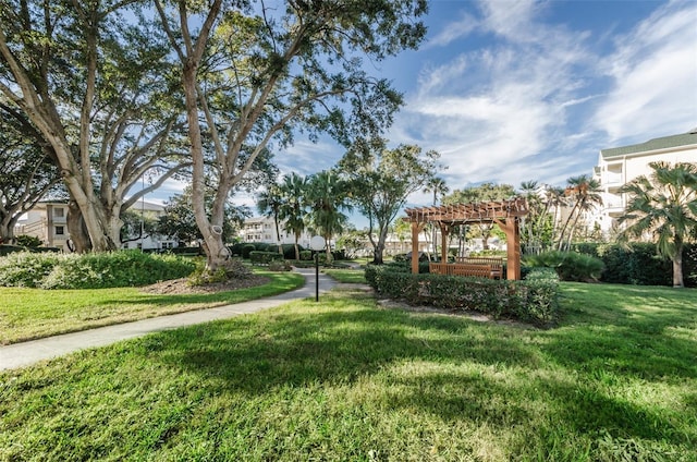 surrounding community featuring a yard and a pergola