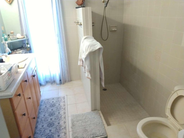 bathroom featuring vanity, tile patterned floors, and a tile shower