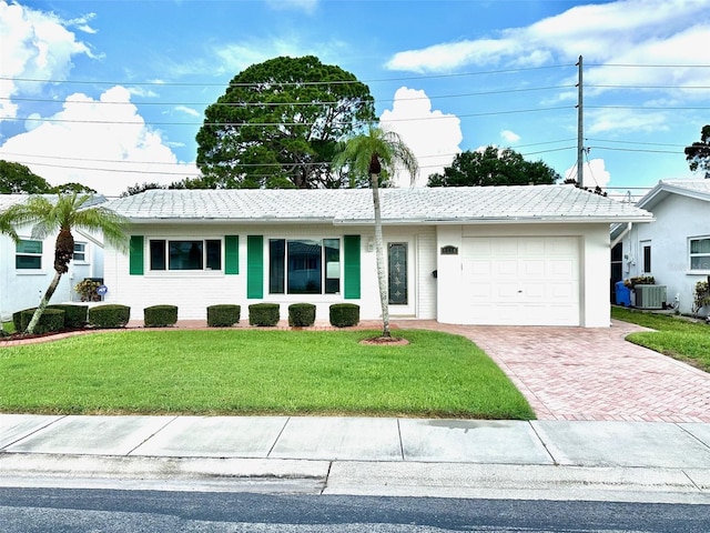 ranch-style house featuring a garage, a front yard, and central AC unit