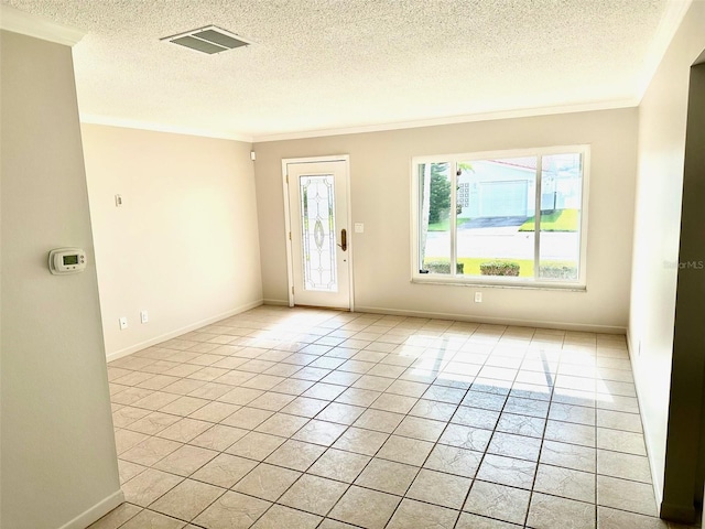 empty room featuring crown molding, a textured ceiling, and light tile patterned flooring