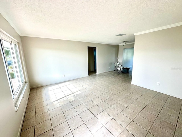 empty room with crown molding, light tile patterned floors, and a textured ceiling