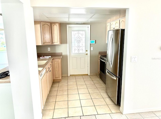 kitchen featuring light tile patterned floors, light brown cabinets, and appliances with stainless steel finishes